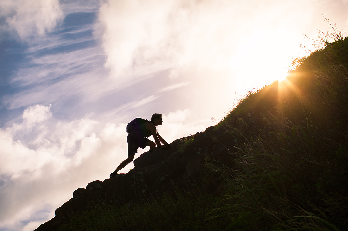 man hiking up a mountain