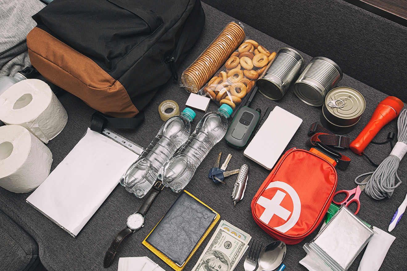 Emergency backpack equipment organized on the table. Documents,